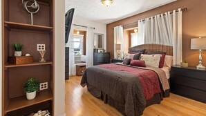 Un dormitorio con cama, mesitas de noche, armario y espejo.