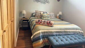 A bedroom with a bed, bedside tables, lamps, a window, and a wall decoration. - Upstairs, downtown Boise, private, close to green belt and Boise State. (Boise)