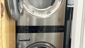 A stacked washer and dryer unit with a control panel, a door, and a label. - Upstairs, downtown Boise, private, close to green belt and Boise State. (Boise)