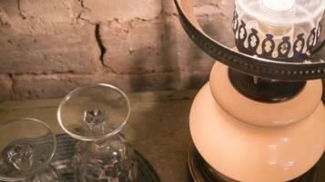 A table with a lamp, a glass, and a woven placemat.