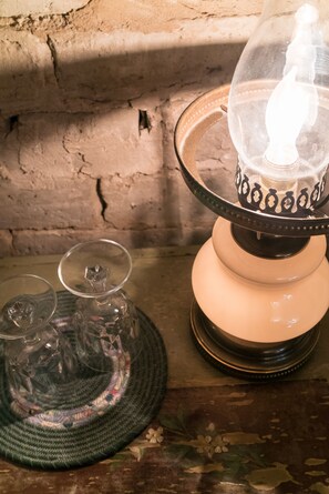 A table with a lamp, a glass, and a woven placemat.