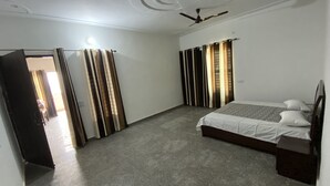 Un dormitorio con cama, cortinas, ventilador de techo y piso alfombrado.