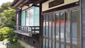 A traditional wooden building with a balcony and large windows. - Hakone Guesthouse toi - Hostel (Hakone)
