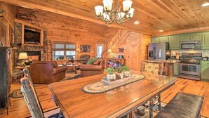 Ein Holzblockhaus-Innenraum mit Essbereich, Wohnzimmer und Küche.