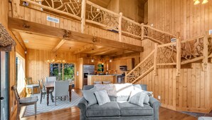 A wooden cabin interior with a dining area, kitchen, and a staircase. - Magnificent Mountain Views (Sapphire)