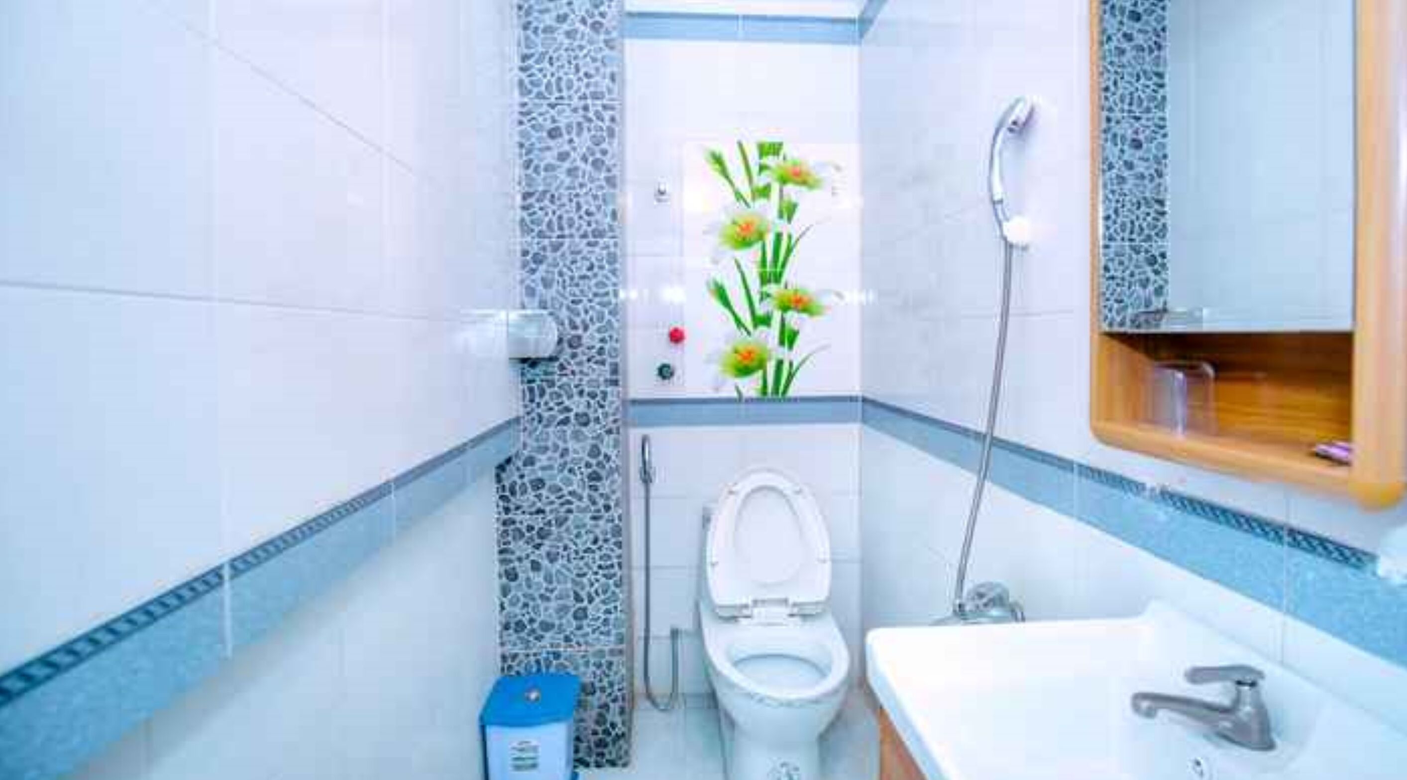 A bathroom with a toilet, sink, and shower.