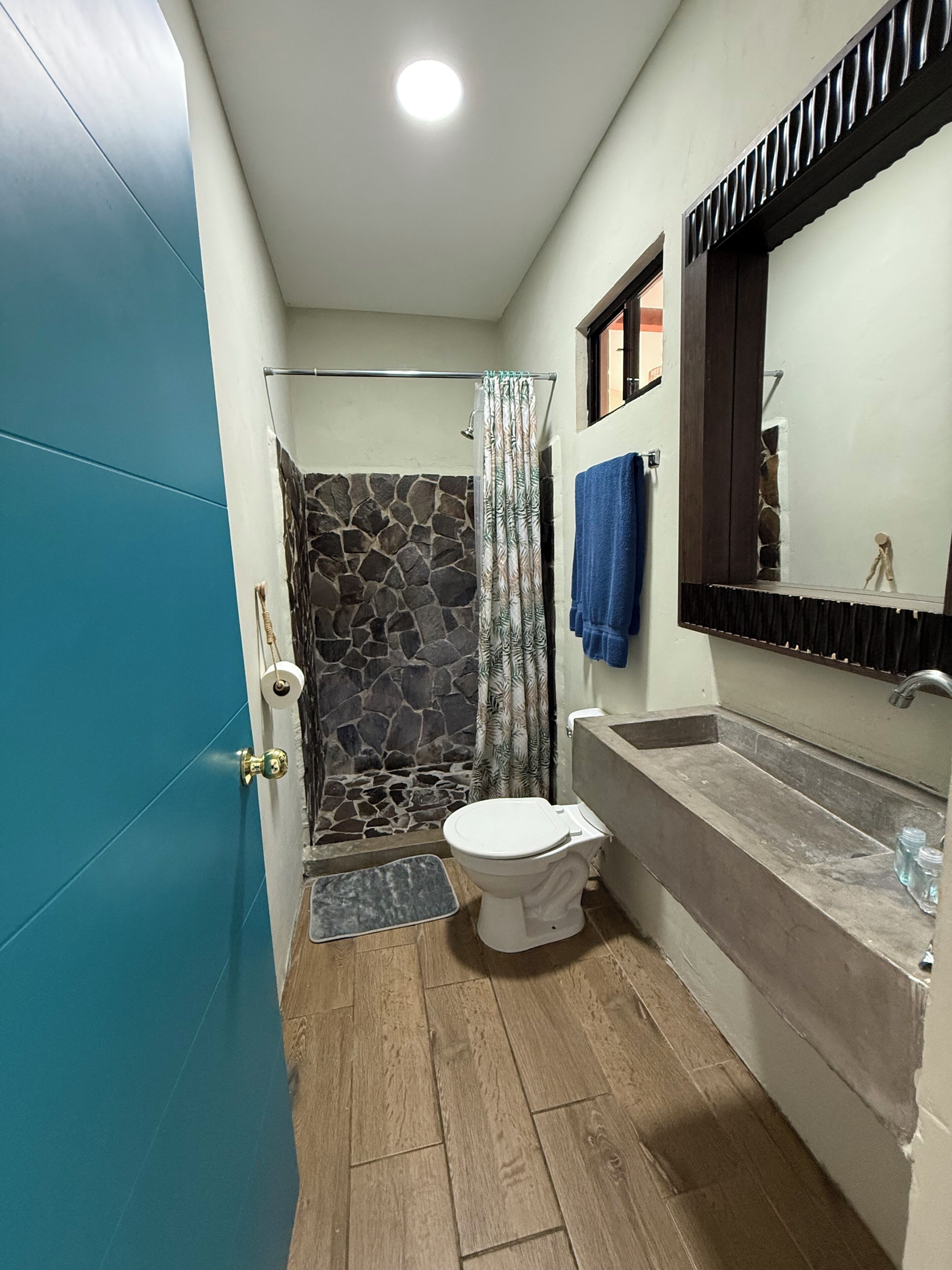 Un baño con ducha, inodoro y lavamanos.