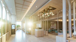 Eine großzügige Hotelhalle mit hoher Decke, moderner Beleuchtung und einer Rezeption.