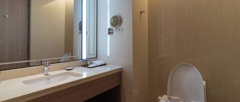 Une salle de bain moderne avec un lavabo, un miroir et des toilettes.