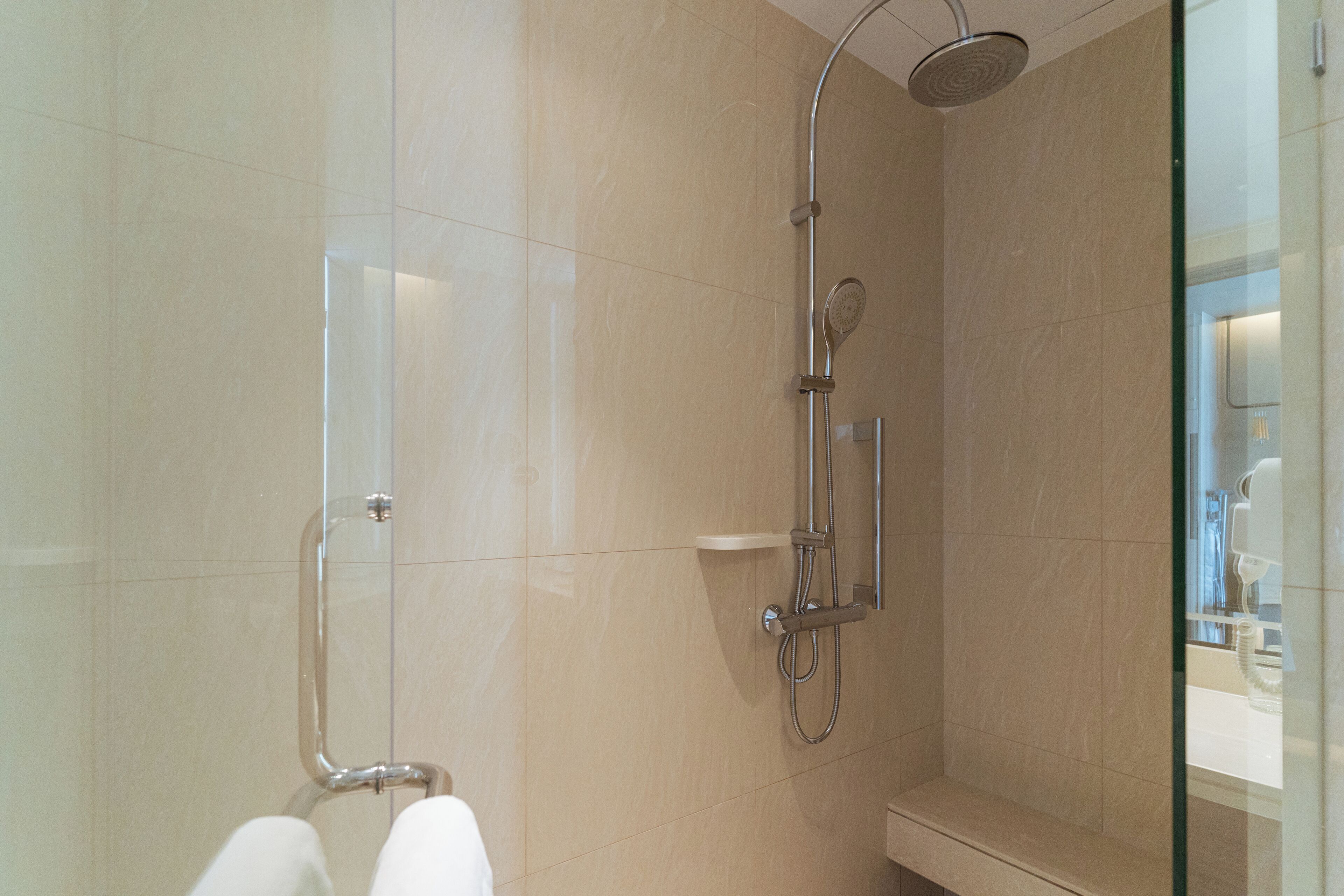 A modern bathroom with a glass shower enclosure, a toilet, and a sink.
