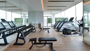 Ein modernes Fitnessstudio mit Laufbändern, Kurzhanteln und Bänken.