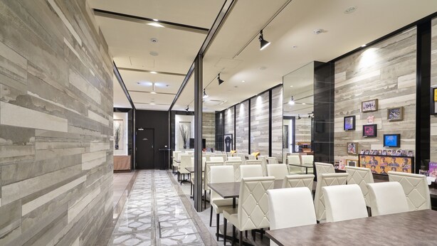 A modern conference room with a long table, white chairs, and a patterned floor. - Hotel Vine Osaka Kitahama (Osaka)