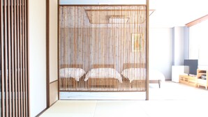 Een traditionele Japanse kamer met tatami vloeren, een shoji scherm en een bed met witte beddengoed.