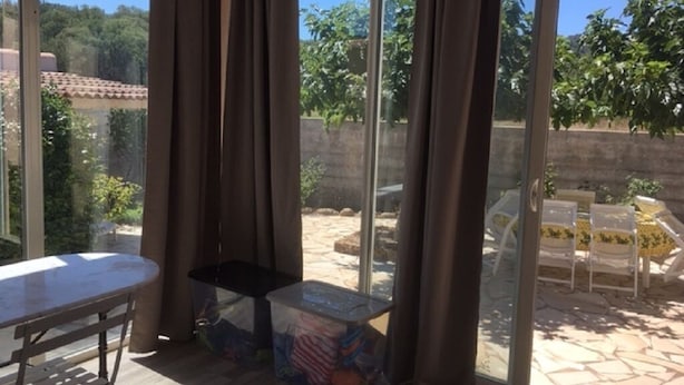 A room with a glass door leading to an outdoor patio area.