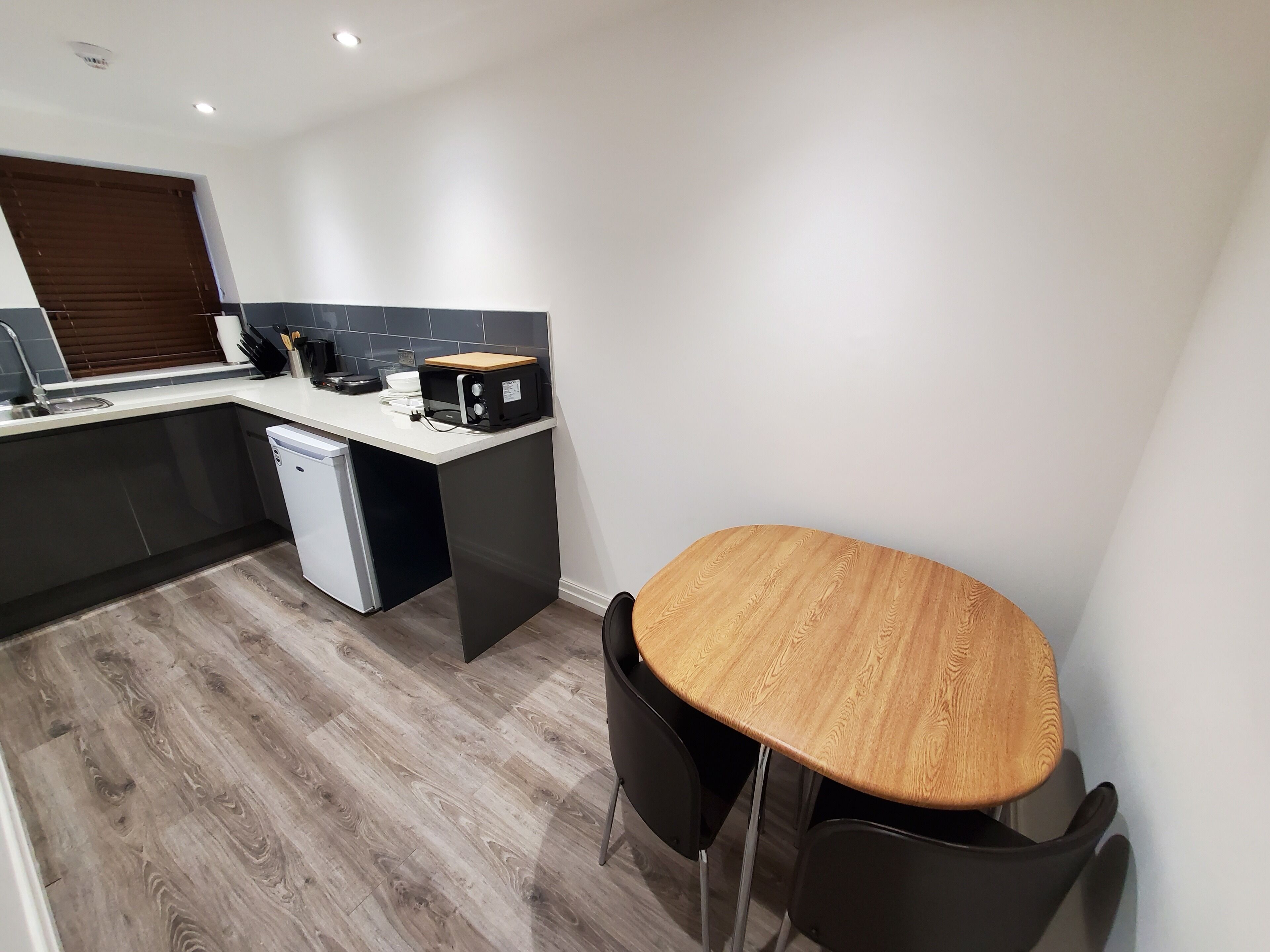 A compact kitchen with a built-in dishwasher, a toaster, and a sink.