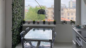A modern kitchen with a dining area, large windows, and a view of the city. - Wonderful apartment in quiet residential complex. (Cattolica)