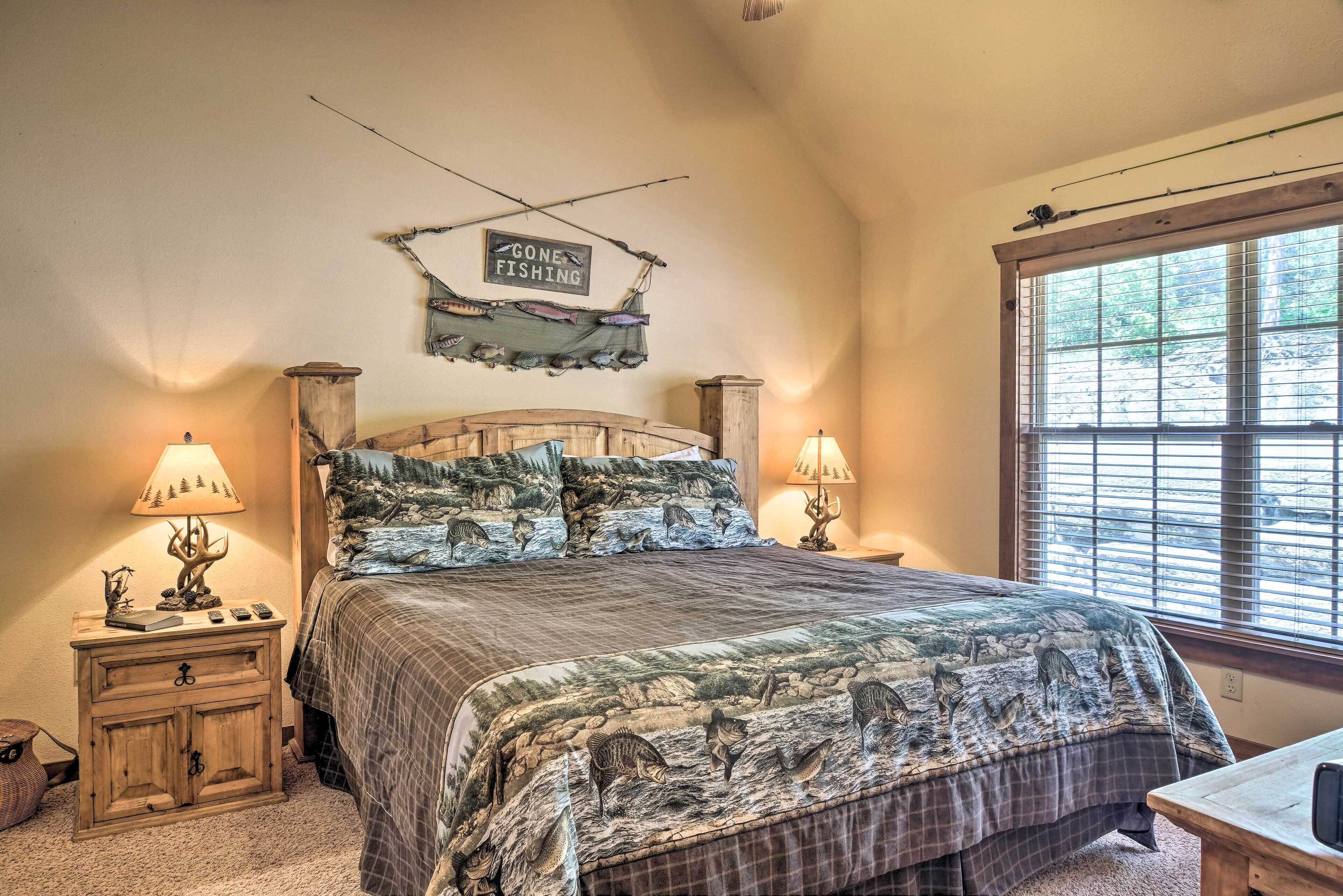A bedroom with a bed, two bedside tables, lamps, a sign, and a window.