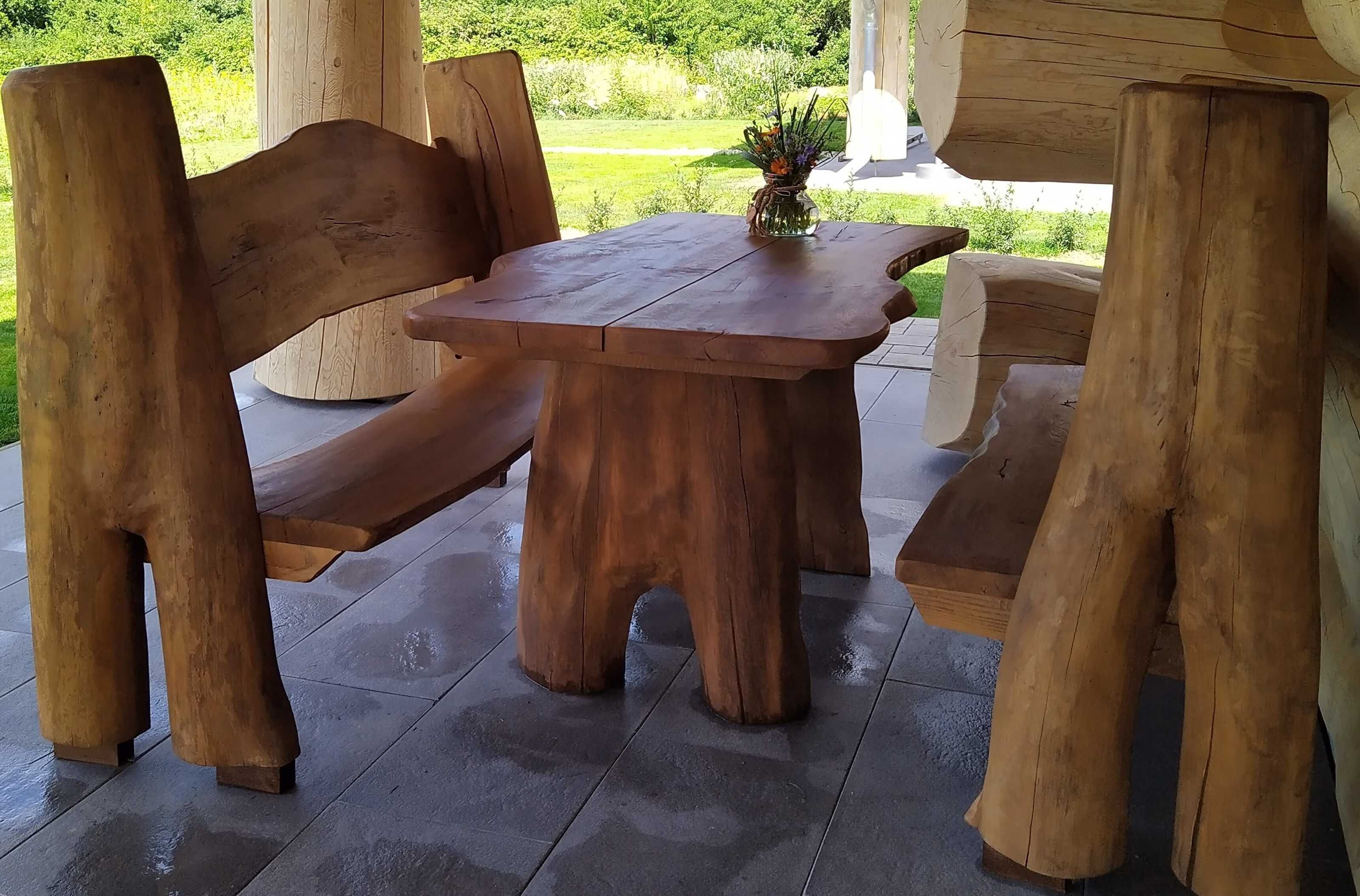 Juego de banco y mesa de madera al aire libre con vista a la vegetación.