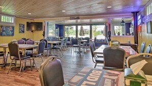 Un restaurante con techos de madera y mesas con la marca 'BUD LIGHT'.