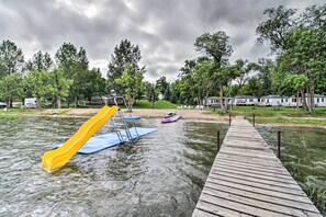 A water park with a wooden dock, a yellow slide, and a blue slide.