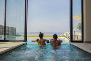A couple in a private hot tub with a view of the beach and ocean. - Hotel Vinci Sirmione (Sirmione)