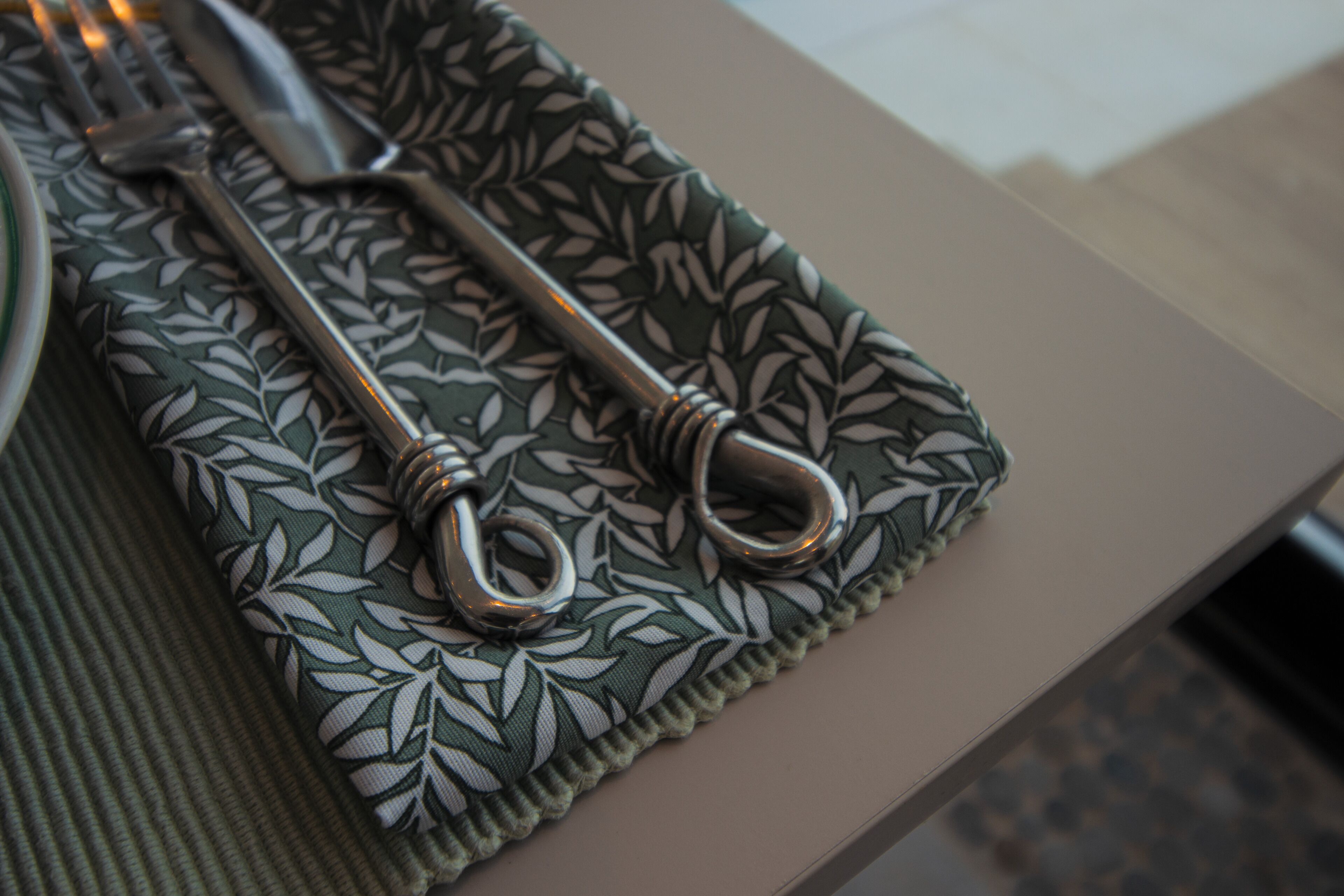 Una disposición de mesa con una servilleta estampada, un tenedor y un cuchillo.