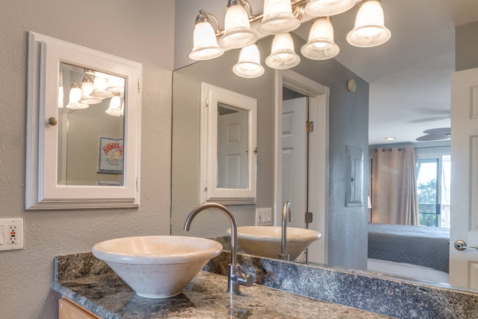 Un bagno con uno specchio grande, un lavabo a incasso e una lampada sopra lo specchio.