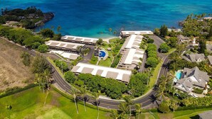 Une vue aérienne d’un complexe hôtelier comprenant plusieurs bâtiments, une piscine et une vue sur l’océan.