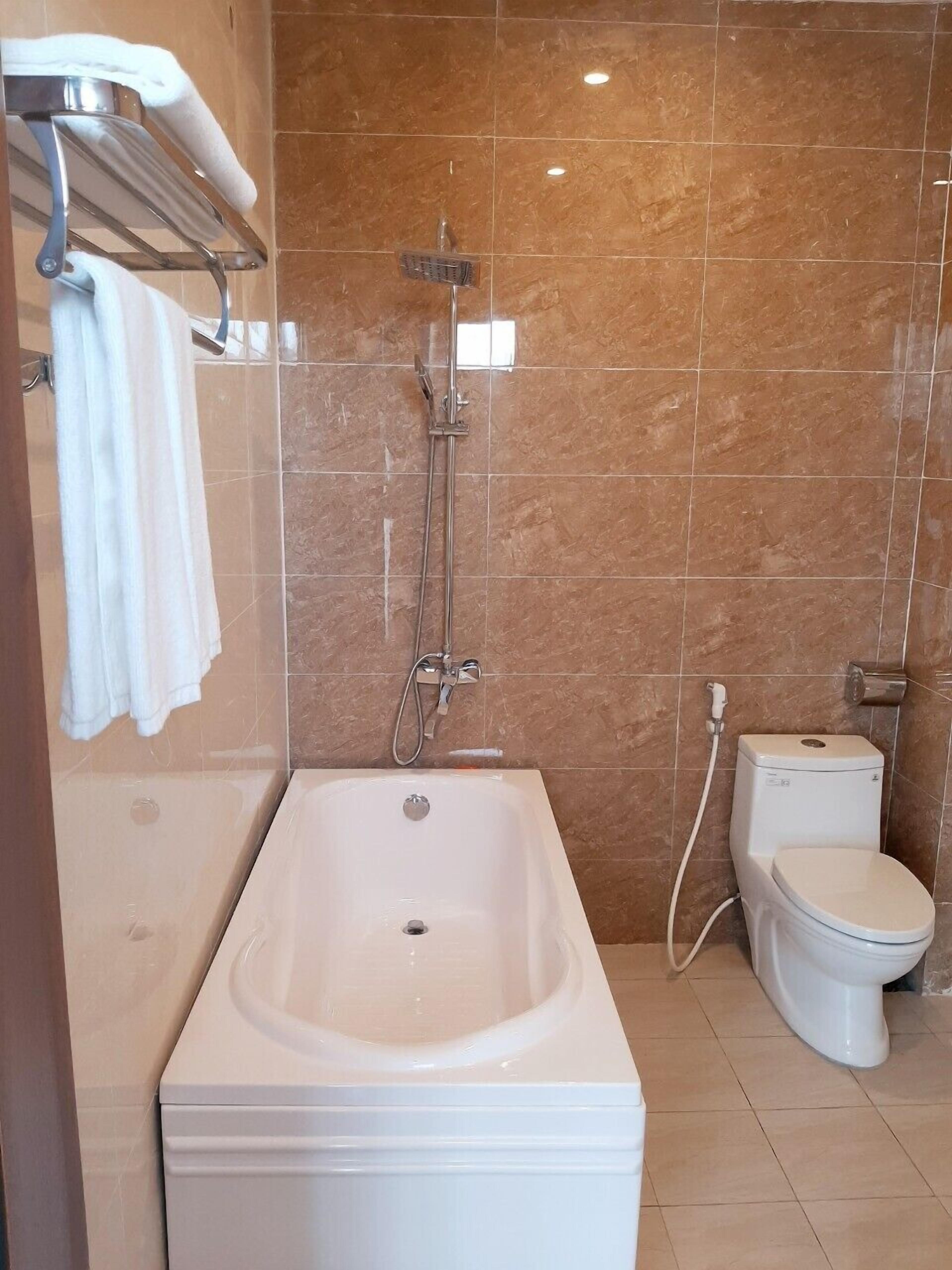 A bathroom with a bathtub, a toilet, and a shower.