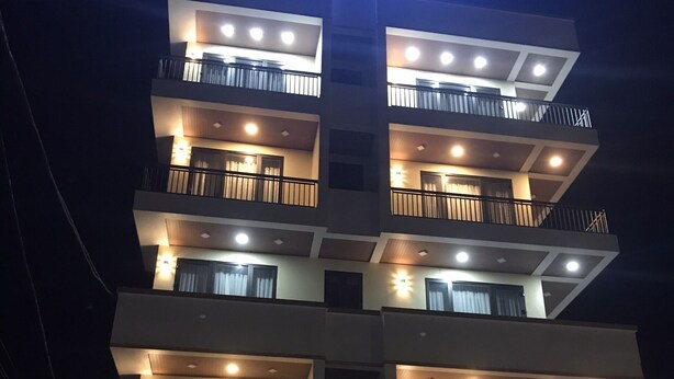 Un hôtel à plusieurs étages, doté de balcons illuminés et d’une enseigne bien visible portant le nom « Korinn ».