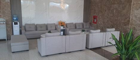 A modern living room with a sectional sofa, a coffee table, and a potted plant.