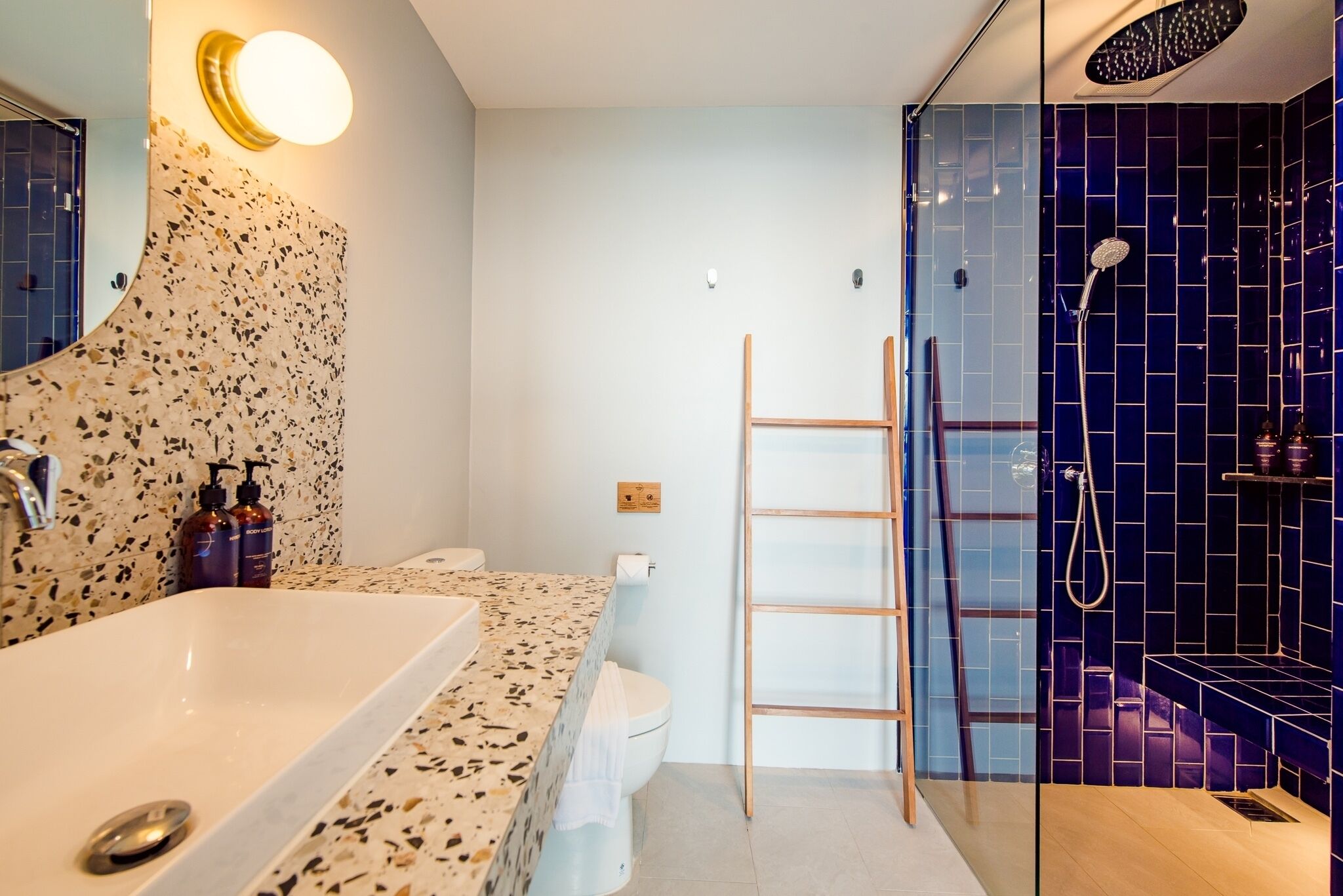 A modern bathroom with a freestanding bathtub, a toilet, and a glass-enclosed shower area.