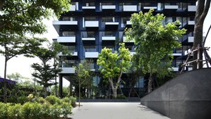 A modern multi-story building with balconies, surrounded by trees and greenery. - Seamira House Huahin (Hua Hin)