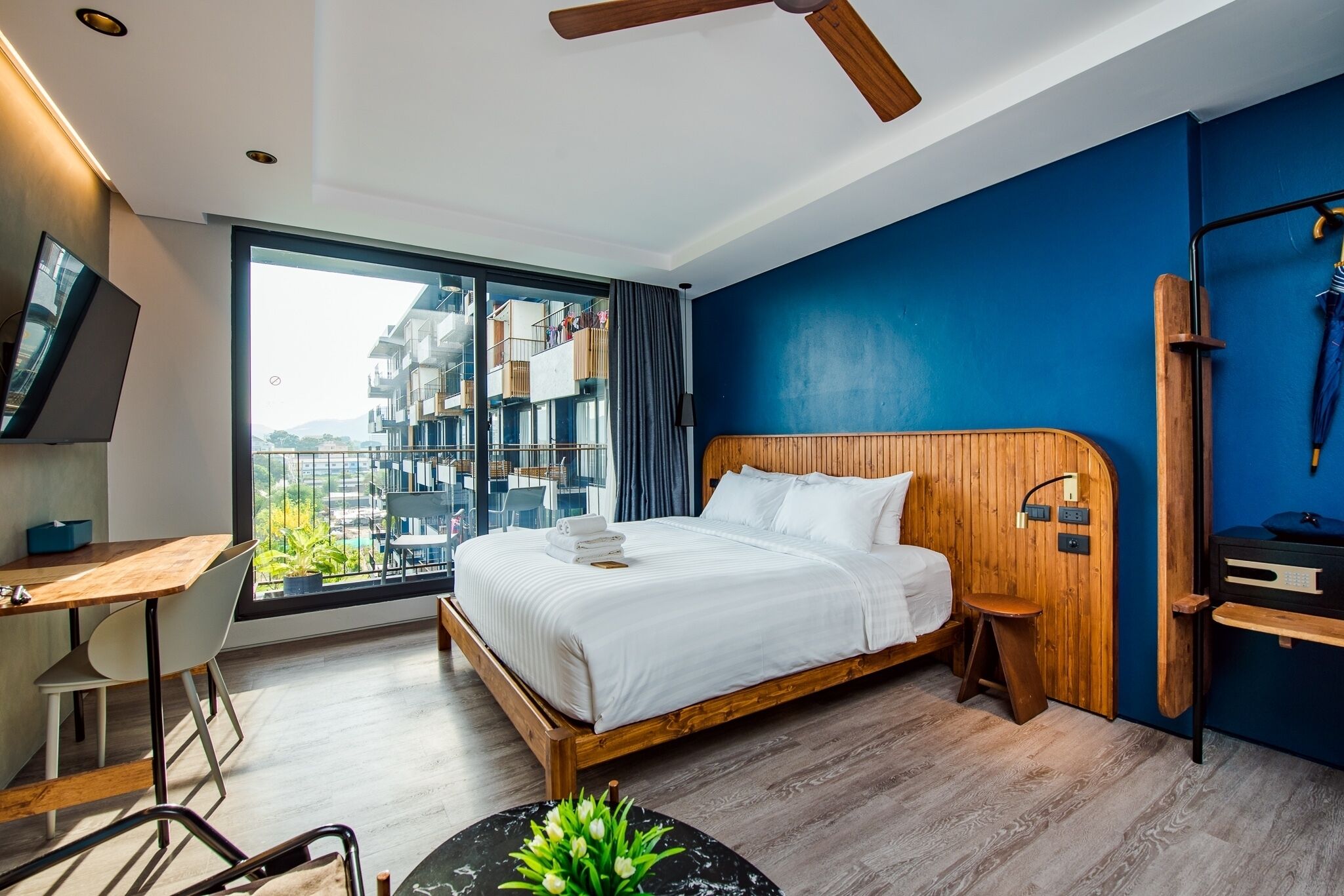 Una habitación de hotel moderna con una cama grande, un escritorio y vistas a la ciudad.