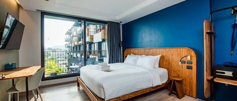 Une chambre d’hôtel moderne avec un grand lit, un bureau et une vue sur la ville.