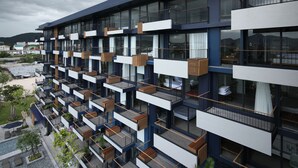 A multi-story hotel with balconies, a swimming pool, and a view of the surrounding area. - Seamira House Huahin (Hua Hin)