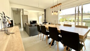 Een moderne keuken met een eethoek, grote ramen en uitzicht op de omgeving.