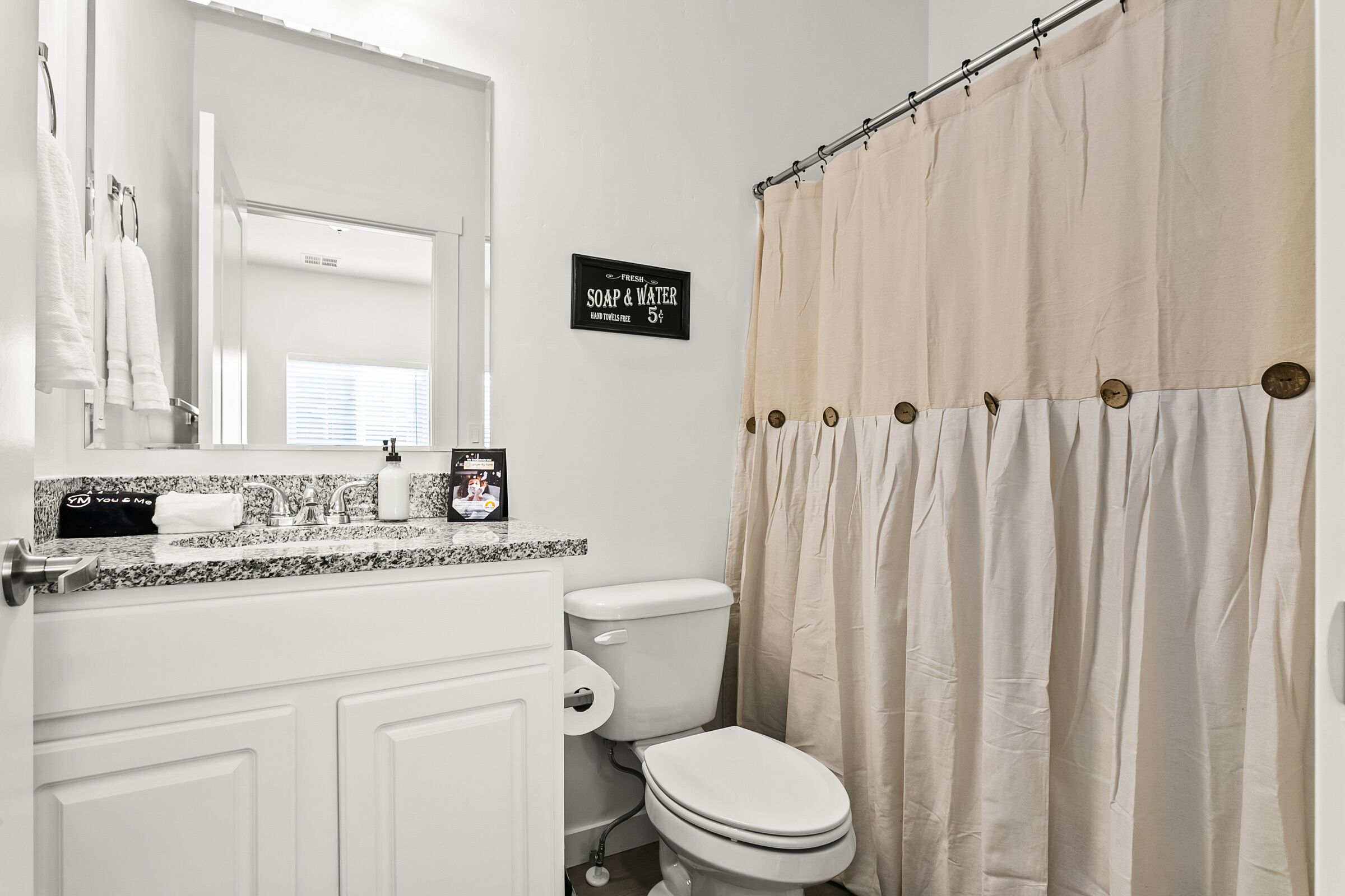 Une salle de bain équipée de toilettes, d’un lavabo et d’un rideau de douche.