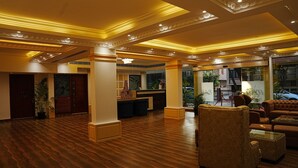 Eine großzügige Lobby mit Holzböden, einer Rezeption und Sitzbereichen.