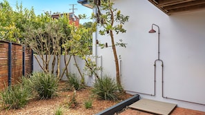 A garden with various plants and a small wooden deck.