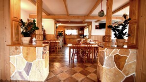 A spacious kitchen with wooden cabinets, a stone island, and a tiled floor. - Willa Dziubas (Poronin)