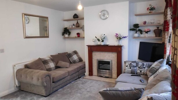 A living room with a sofa set, a fireplace, a television, and decorative shelves. - Worcester Town Centre Home & Garden (Worcester)
