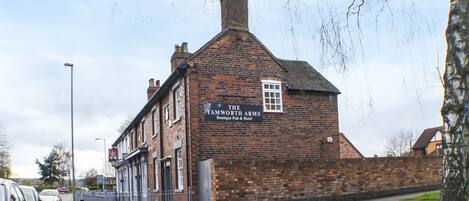 Un edificio de ladrillo tradicional con un letrero que dice 'The Tamworth Arms Boutique Pub & Hotel'.