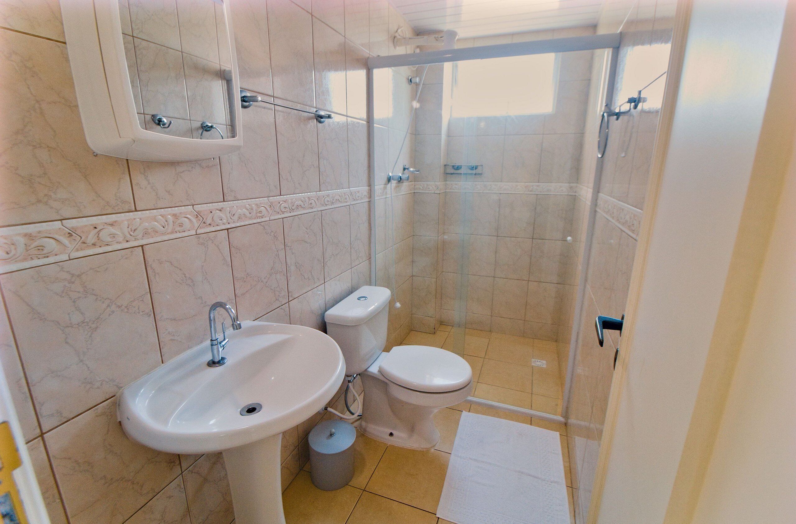 Un bagno con lavandino, wc e doccia.