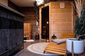 Ein Saunaraum mit Holzbänken, einem kleinen Teppich und einem Blumentopf.