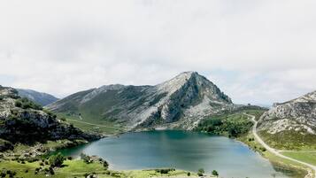 Un paisaje montañoso con un lago, carreteras y vegetación.