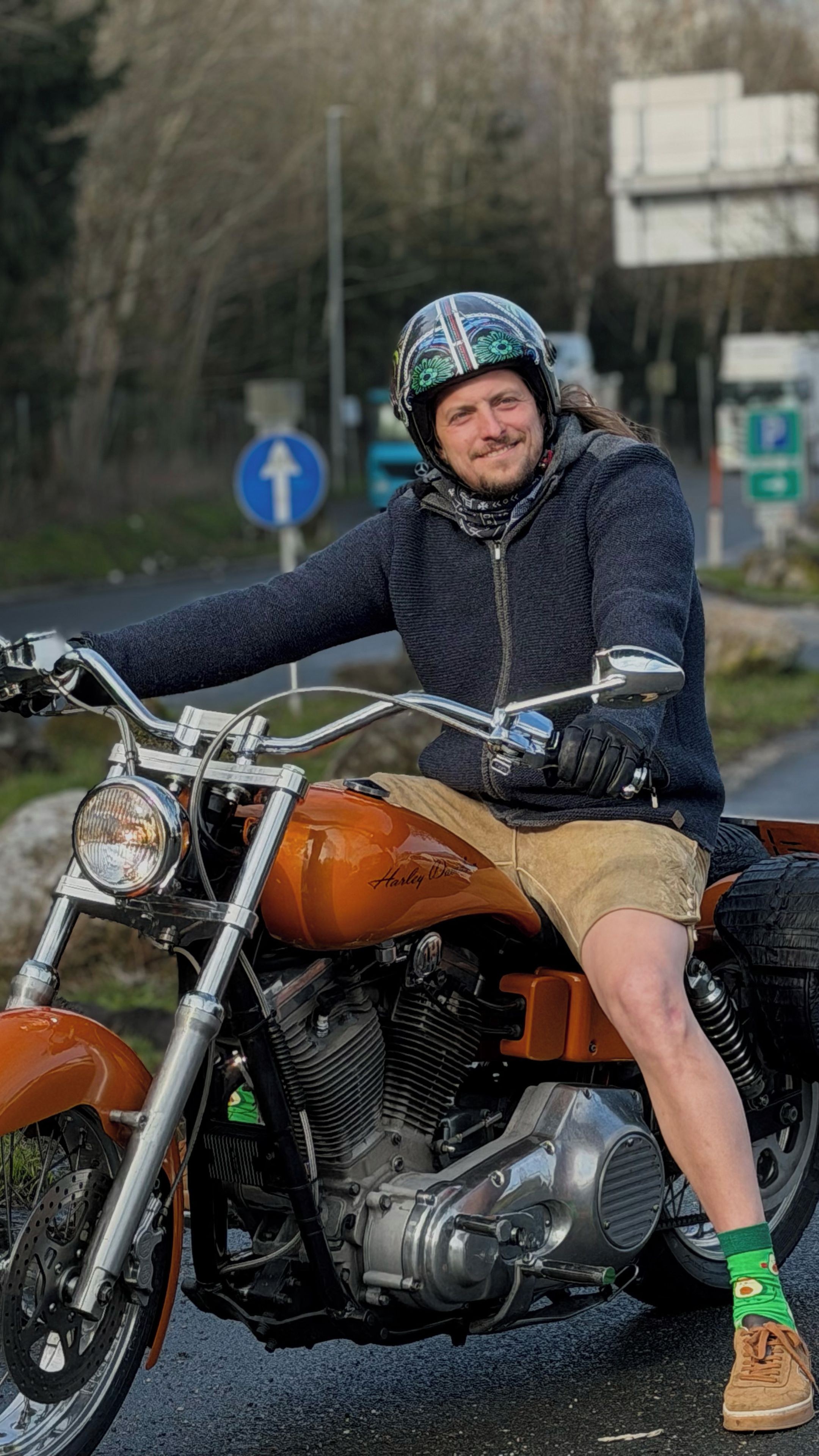 Eine Person sitzt auf einem Motorrad, wobei Motor und Lenker gut sichtbar sind.