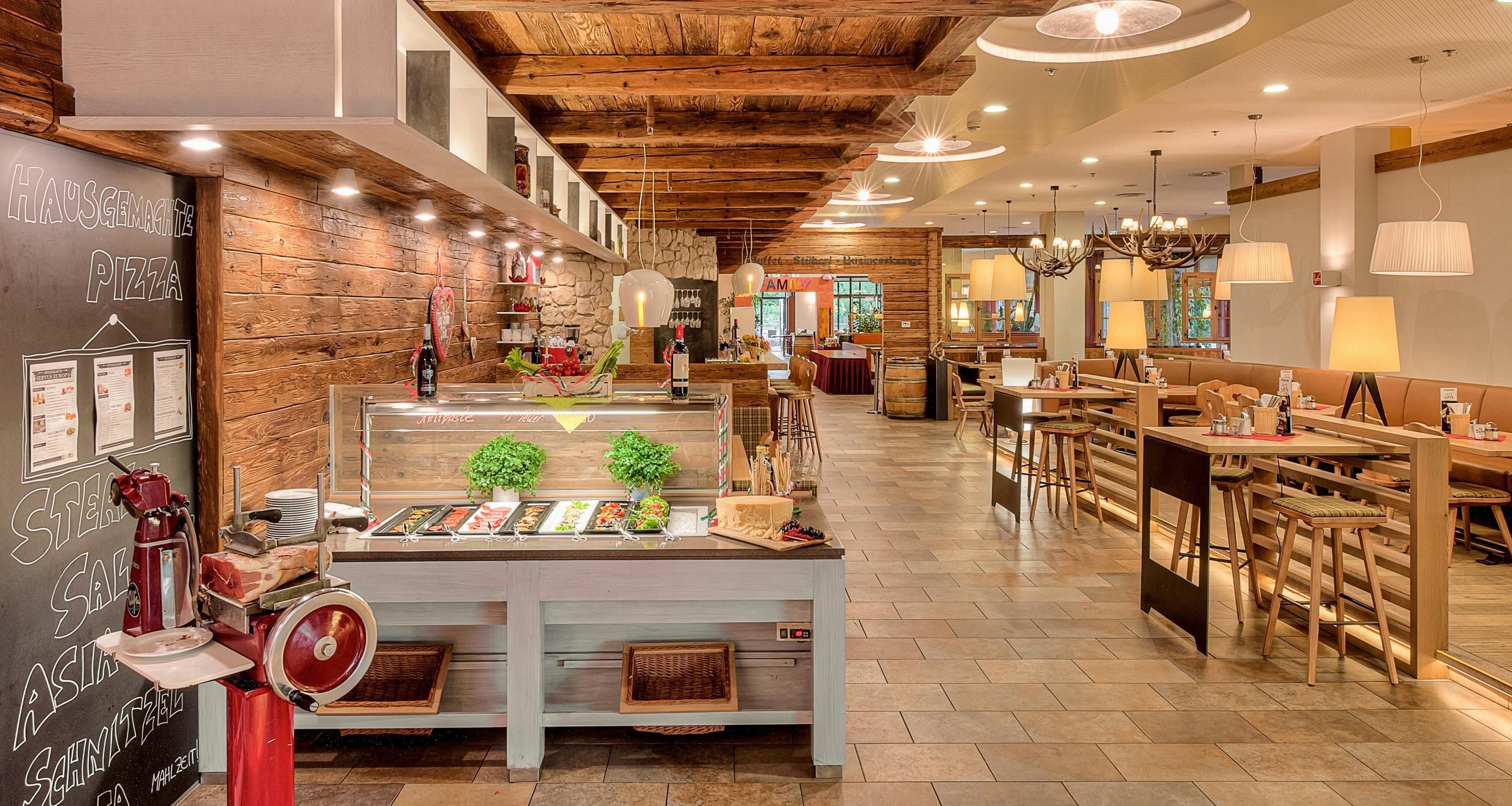 A restaurant interior with a wooden ceiling, a buffet counter, and seating areas.