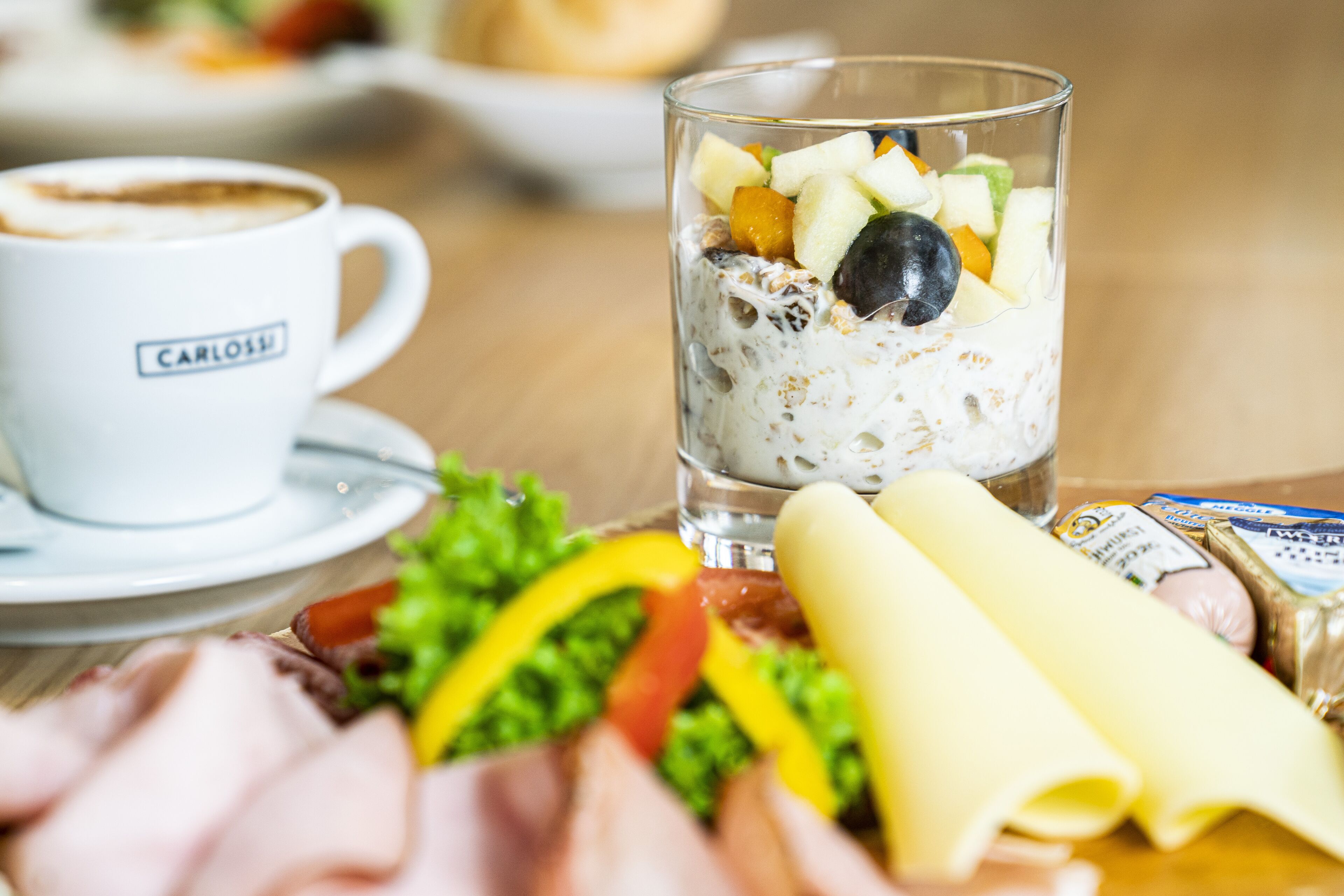Ein Frühstückstisch mit Fruchtsalat, einer Kaffeetasse und verschiedenen Speisen.
