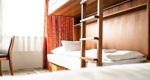 Una cama litera con estructura de madera, un colchón blanco y almohadas.
